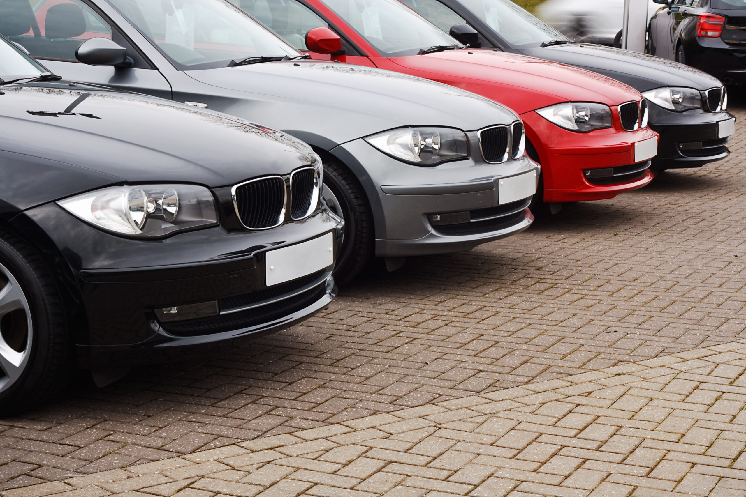 row of prestige used cars for retail sale in a motor dealers yard showing same model in different colour choices